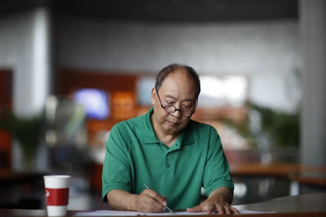 朱绍玉伏案执笔、伏案创作工作照(澎湃新闻“上海访谈”栏目配图)