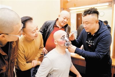 专场演出前,石晓亮(右一)为弟子权守昌(右二)扮戏(天津市文化和旅游局)