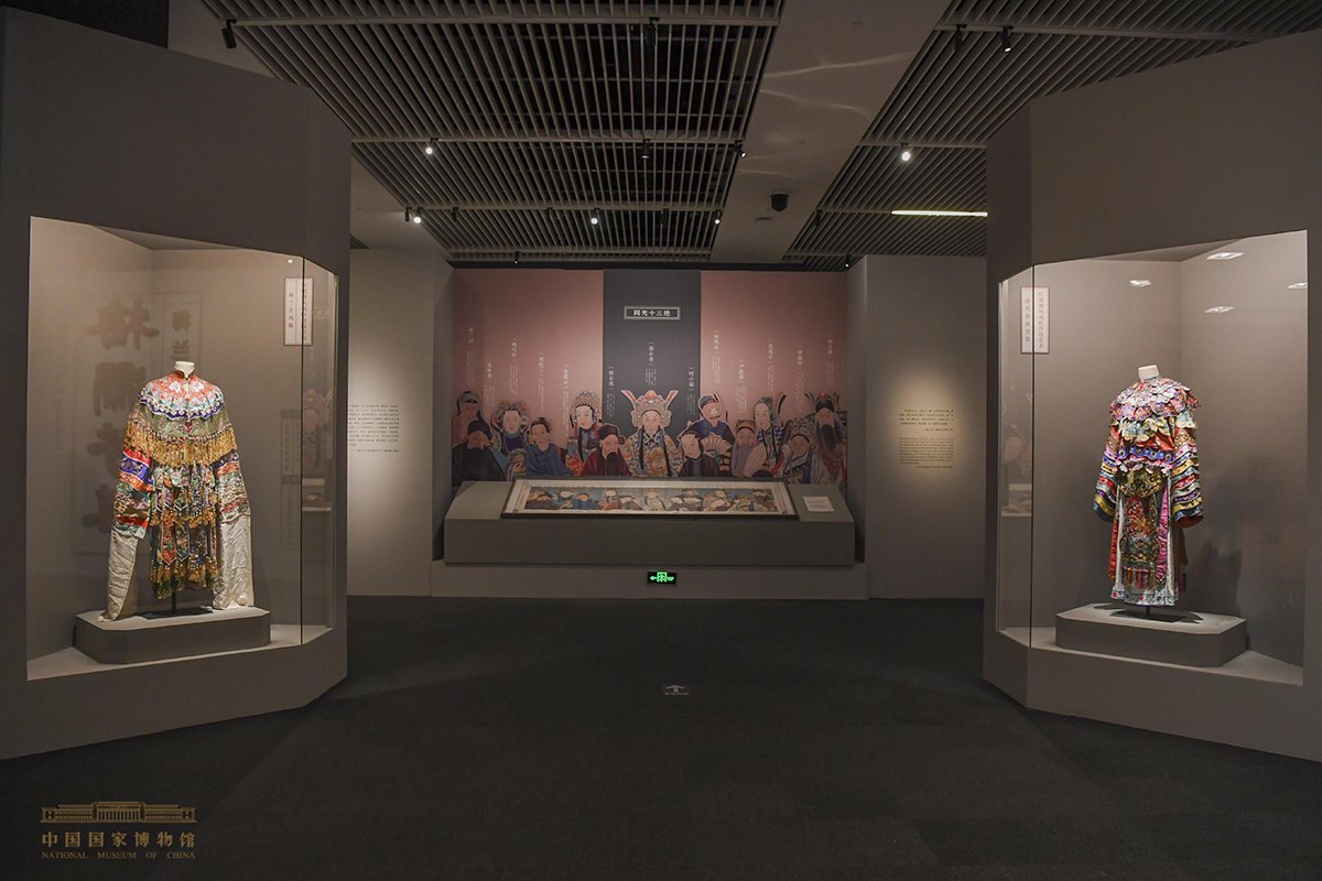 中国国家博物馆“梅澜芳华——梅兰芳艺术人生展”“同光十三绝”展区(正面墙放大《同光十三绝》群像,中央展柜平置长卷,两侧陈列戏衣;展厅现场照片,非程长庚本人影像)