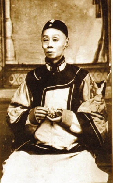 谭鑫培便装照（清末民初照相馆拍摄，戴瓜皮帽、着深色对襟马甲与浅色长衫，坐姿半身像；本人影像）