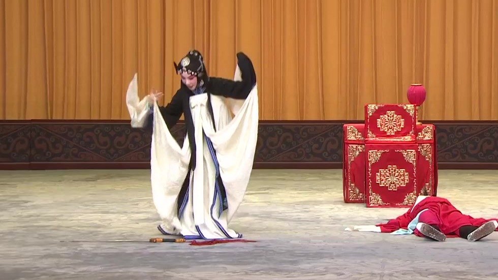 京剧《审头刺汤》「刺汤」录像截帧:雪艳(旦,左)与被刺倒地的汤勤(丑,右)