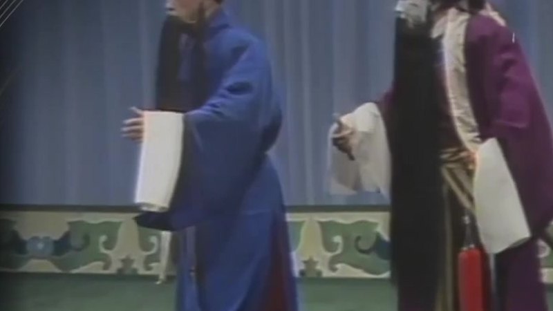 京剧《捉放曹》录像截帧:陈宫(左,老生,戴黑方巾挂黑三)与曹操(右,净角,勾白脸挂黑满)对面做戏(表演:李鸣盛、梁嘉禾)