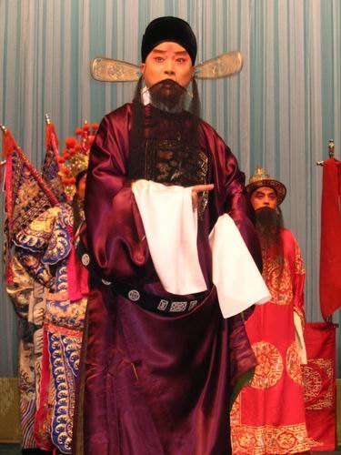 京剧《群英会》剧照：老生、扎靠净角与持书官员同场（国家京剧院官网剧目页所载）